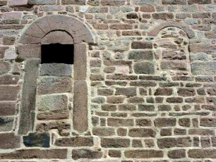 Evangelische Kirche - Kirchturm von Süden (romanisch gegründet)-alter Eingang im ersten Mittelgeschoß (vermauert) sowie vermauertes Rundbogenfenster im Detail mit Werksteinen im Mauersteinverband