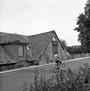 Denkmal: Kupfermühle mit beschädigtem Dach und in desolatem Zustand: vorn Kupfermühlenweg: rechts Geländer: im Vordergrund Fahrradfahrer