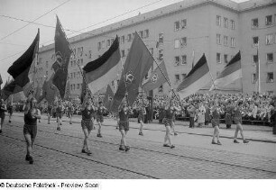 Sportler (Fahnenschwinger) während einer Parade auf der Straße der III. Weltfestspiele (heutige Jahnallee)