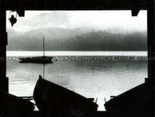 Blick auf Ruderboote, im Hintergrund ein See mit nebeliger Landschaft (Altersgruppe bis 14)