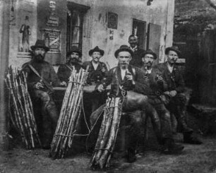 Ottendorf, Kreis Sebnitz. Ottendorfer Waldarbeiter mit Leseholzbündeln vor dem Gasthaus "Zeughaus" im Großen Zschand sitzend. (hinten der Wirt). Photographie um 1900. Privatbesitz, Sebnitz