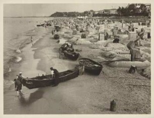 Seeheilbad Bansin. Strandleben. Zahlreiche Strandkörbe und Fischerkähne am Sandstrand. Fischer bei der Arbeit