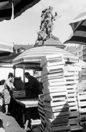 Mannheim: Brunnenfigur hinter Marktkisten