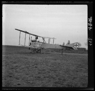 [Vitry-en-Artois (Dep. Pas-de-Calais, Frankreich):] Doppeldecker mit schwarzem Tatzenkreuz am Seitenruder auf einem Flugfeld