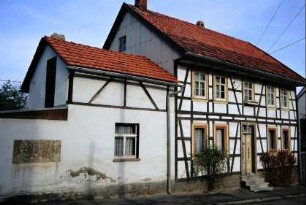 Fachwerkhaus mit zweiflügeliger Eingangstür zur Straße; Anbau