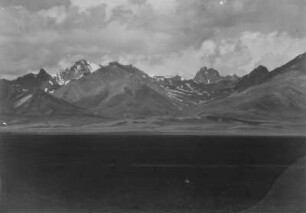 Gebirgszug : Panorama einer Ebene vor einem schneebedeckten Gebirgszug im Tian Shan Hochgebirge
