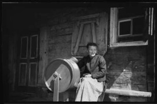 Bäuerin vor einem Holzhaus im Kleinwalsertal