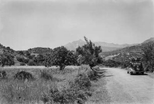 Straße : Von einer Straße durchschnittene Landschaft in Richtung eines Gebirgspasses