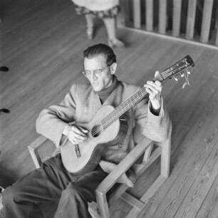 Mann mit Brille spielt Gitarre