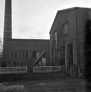 Brand: Bargfelder Straße: Warenlager des "Abholmarkts Elmenhorst" [ehemaliges Meiereigebäude]: Inhaber und Mitarbeiter vor Brandruine