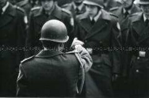 Rückenansicht eines Soldaten mit Helm, der mit dem Finger auf einen anderen Soldaten weist