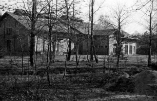 Wasserwerk: davor Grünanlage mit Bäumen: vorn rechts Sandhaufen