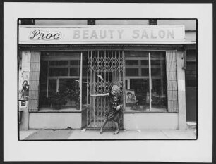 Beauty Salon : Frau im schwarzen Kleid öffnet das Schiebegitter eines New Yorker Beauty Salons