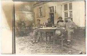 Gruppe trinkender Soldaten vor Haus