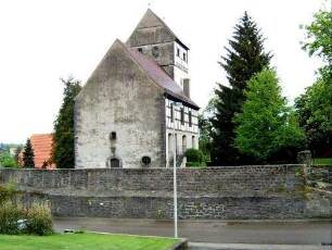 Ansicht von Westen mit Kirche (im Kern Gotischer Neubau auf Vorgänger) in erhöht liegendem Kirchhof über Kirchhofmauer (Wehrgang mit Steinbrüstung im 18 Jh abgetragen)