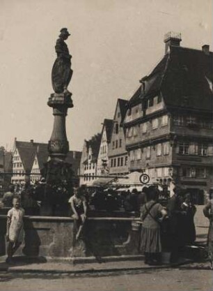 Banden-Würtemberg. Biberach an der Riß. Ansicht des 1678 geschaffenen barocken Marktbrunnen. Die Ritterfigur des Marktbrunnens hält in ihrem linken Arm das 1488 entstandene Biberacher Stadtwappen – der goldene Biber auf blauem Grund. Am Brunnen stehen und sitzen Menschen