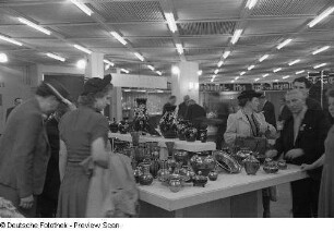 Fachbesucher an einem Messestand mit Keramikvasen