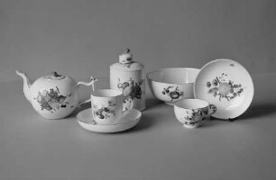 Eine Teekanne, eine Kaffee- und eine Teetasse mit Untertassen, eine Teedose und eine Kumme mit Früchtedekor
