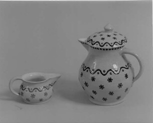 Sahnekännchen und Kanne eines Kaffeeservices : Sahnekännchen und Kanne eines Kaffeeservices. Irdenware, Engobe, bemalt, glasiert; H. 7,1 cm und H. 17, 5 cm (1. H. 20. Jh.; K. Feuerriegel). Museum im Schloß Frohburg V 568/96, V 569/96