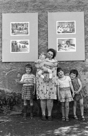 Frau Ludewig mit ihren Kindern vor Tafeln der Freilichtausstellung