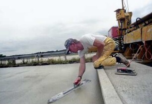 BAB A7 Hamburg-Hannover, zwischen Egestorf und Bispingen. Aus-/Neubau einer Fahrbahn. Die Betondecke wird maschinell gegossen und geglättet. Anschließend werden per Hand Fehler ausgebessert