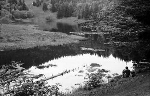 Sitzender Wanderer am Ufer des nonnenmattweihers bei Neuenweg