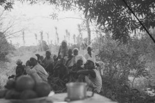Interessierte Zuschauer : Landschaft mit einer Gruppe von Dorfbewohnern die das Lager in Mingumbi besuchen