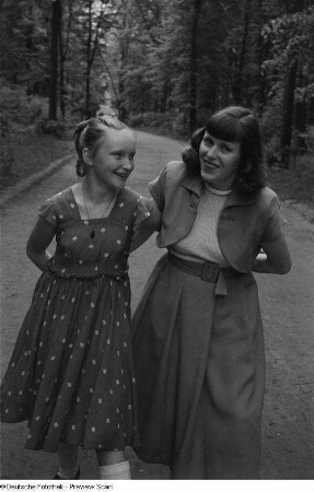 Renate Rössing (rechts) mit einem Mädchen, einen Parkweg entlanggehend