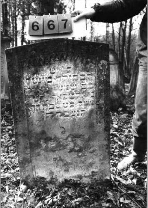 Grabstein 667 (Index: 99752424) Material: Sandstein Zustand: abgeblätt/verwittert/Textverlust Maße HxBxT: 100x60x12 cm Beschreibung: Stele, giebelartiger Abschluß, Schriftfeld eingetieft Symbolik: Spitzbogenfries: Grabstein 667