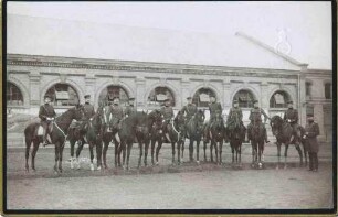 Offiziere (elf Personen) des Regiments zu Pferd, einer stehend vor Kasernengebäude (?)