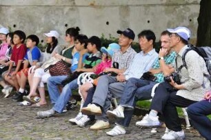 Chinesische Touristen : Chinesische Touristen sitzen im Innenhof des Strahov-Klosters auf einer Bank. Aufgenommen in Prag am 31. Juli 2009