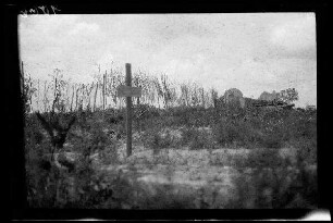 Nicht identifizierbare Gegend zwischen Comines (=Comines-Warneton, Belgien) und Messines (=Mesen, Belgien): Soldatengrab mit Holzkreuz, im Hintergrund eine Gebäuderuine