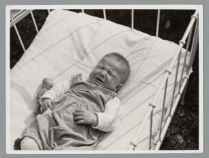 Portrait eines Kleinkindes in Kinderbett liegend