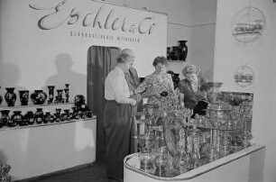 Vier Personen am Stand von Eschler & Co. Glasraffinerie Meiningen auf der Leipziger Herbstmesse 1955