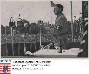 Hitler, Adolf (1889-1945) / Sammelwerk Nr. 15 'Adolf Hitler', Bild Nr. 38, Gruppe 64 / Porträt Adolf Hitlers in Uniform auf Rednertribüne vor Menschenmenge, stehend, im Halbprofil, Kniestück