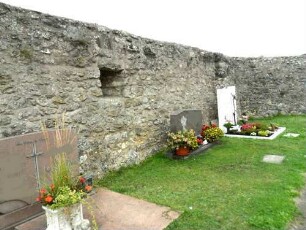 Kirchhof im Nordnordosten mit Kirchhofmauer und Schießscharte in Brusthöhe (Wehrgang im 18 Jh abgetragen)-im Nordosten Mauerverdickung (Basis eines ehemaligen Erkers)