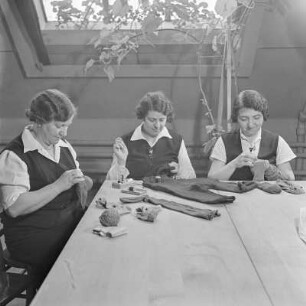 Werkfrauen beim Flicken von Kleidungsstücken