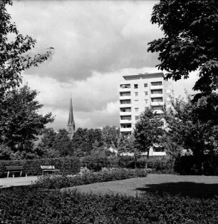 Kurpark: Hecken, Blumenrabatten und Bänke: hinten rechts Hochhaus "Liebe" an Kurparkallee: hinten links Turm der Peter-Paul-Kirche
