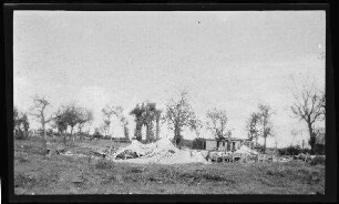 Hallu (Dep. Somme, Frankreich): zusammengestürztes Zeltgebäude auf einem Feld mit umstehenden Bäumen ("zerschossenes englisches Lazarett")