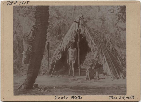 Two Guató in front of a hut