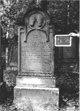 Grabstein 536 (Index: 99895462) Material: Sandstein Zustand: teilweise verwittert Maße HxBxT: 168x58x20 cm Beschreibung: Stele mit eingezogenem Rundbogenabschluss und kleiner Verdachung, Akroteren; getreppter Sockel Symbolik: Priesterhände: Grabstein 536 (1)