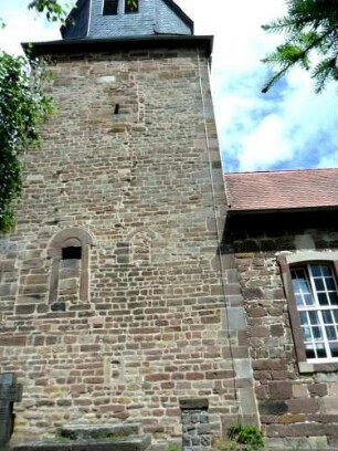 Evangelische Kirche - Kirchturm von Süden (romanisch gegründet) mit Werksteinen im Mauersteinverband (alter Eingang im Mittelgeschoß - Biforium im Obergeschoß vermauert mit Schießscharte versehen)