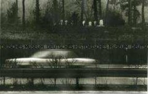 Auto fährt auf nachtdunkler Straße an Gräbern vorbei (Prämiertes Foto Altersgruppe 18-21)