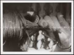 Hand mit Haarsträhne und Lockenwickler (Sonderpreis Photoindustrie)