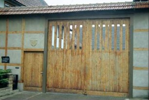 Gehöfteinfahrt mit erneuerter oder neuer Fachwerkmauer, überdachtes Tor