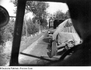 Deutschland . Truppenübungsplatz Klietz. Nationale Volksarmee - Landstreitkräfte. Marschkolonne der Artillerie. Blick aus einem Fahrerhaus auf vorausfahrenden Lastkraftwagen mit angehängtem Geschütz