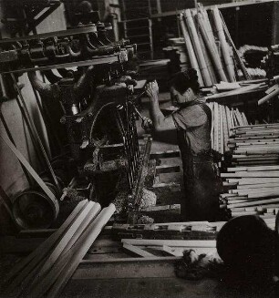 Arbeitende Frau an einer Maschine (Holzverarbeitung)