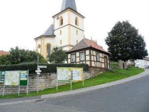 Ansicht von Nordosten mit Kirche (im Kern spätromanisch) über Kirchhofmauer (Wehrgang mit Steinbrüstung im 18 Jh abgetragen) in erhöhter Lage am Ortsrand