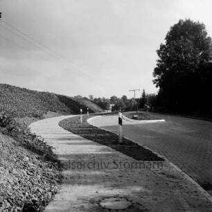 Straßenbau: Oldesloer Straße: Ausbau: Ortseingang mit Verkehrsinsel und Radfahrweg: rechts Bäume