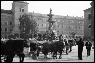 Salzburg: Brunnen am Residenzplatz, mit Fiakern
